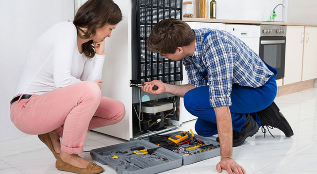 Technician repairing fridge